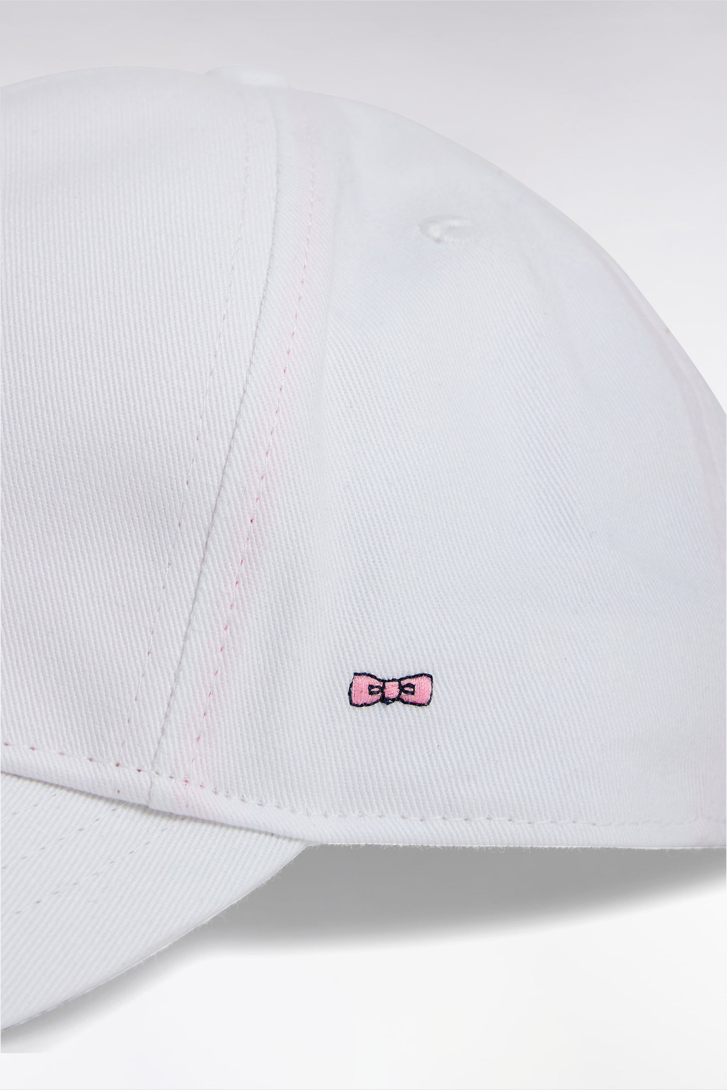 White cotton twill cap with bow tie embroidery