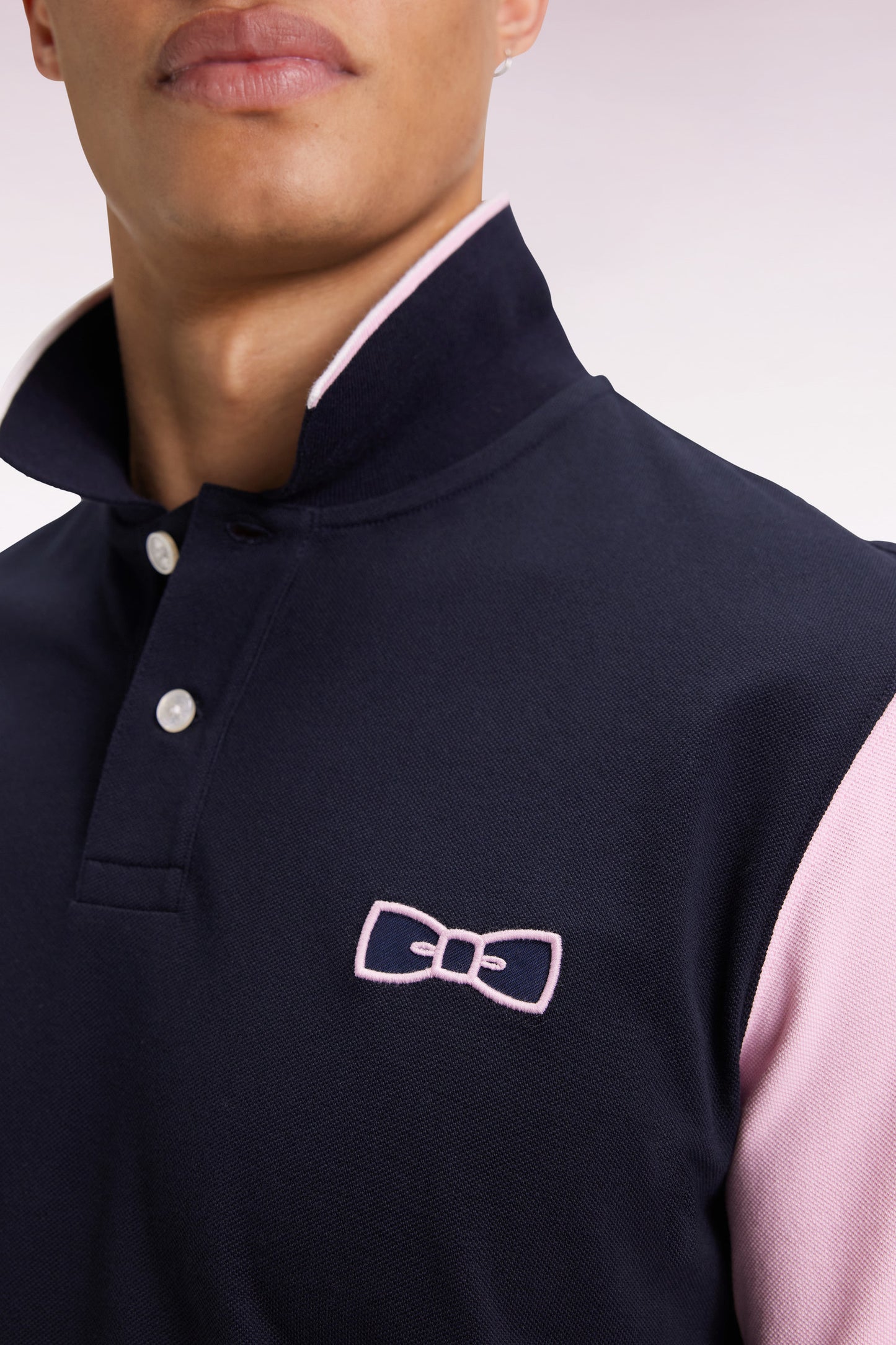 Two-tone navy and pink long-sleeved polo with bow tie